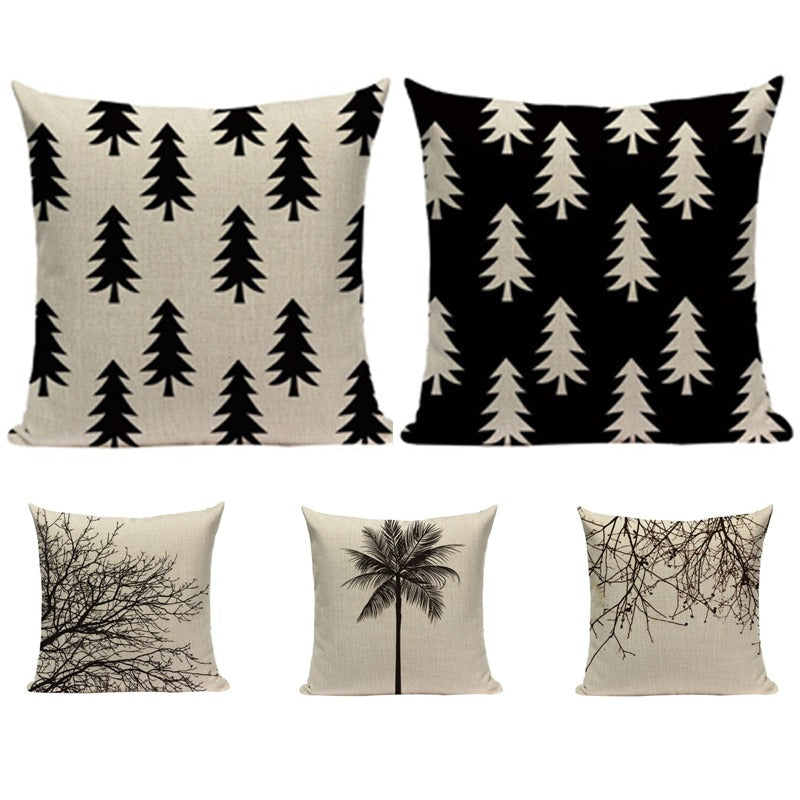 Five cream and black cushion covers with tree, branch and palm designs.