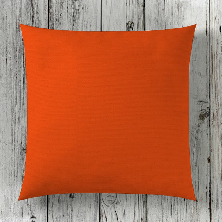 Plain orange cushion cover displayed against wooden boards.