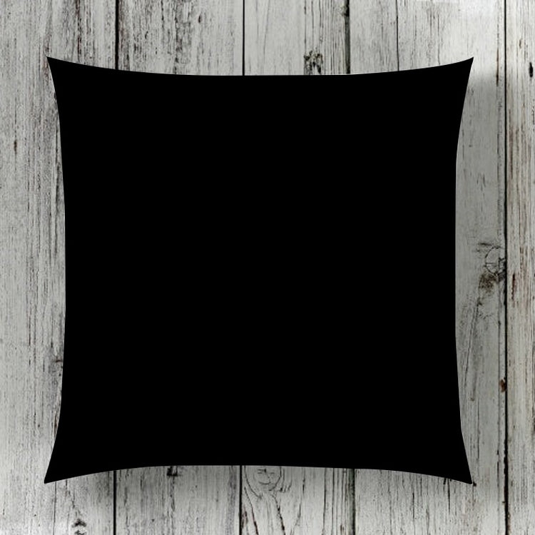 Plain black cushion cover displayed against wooden boards.
