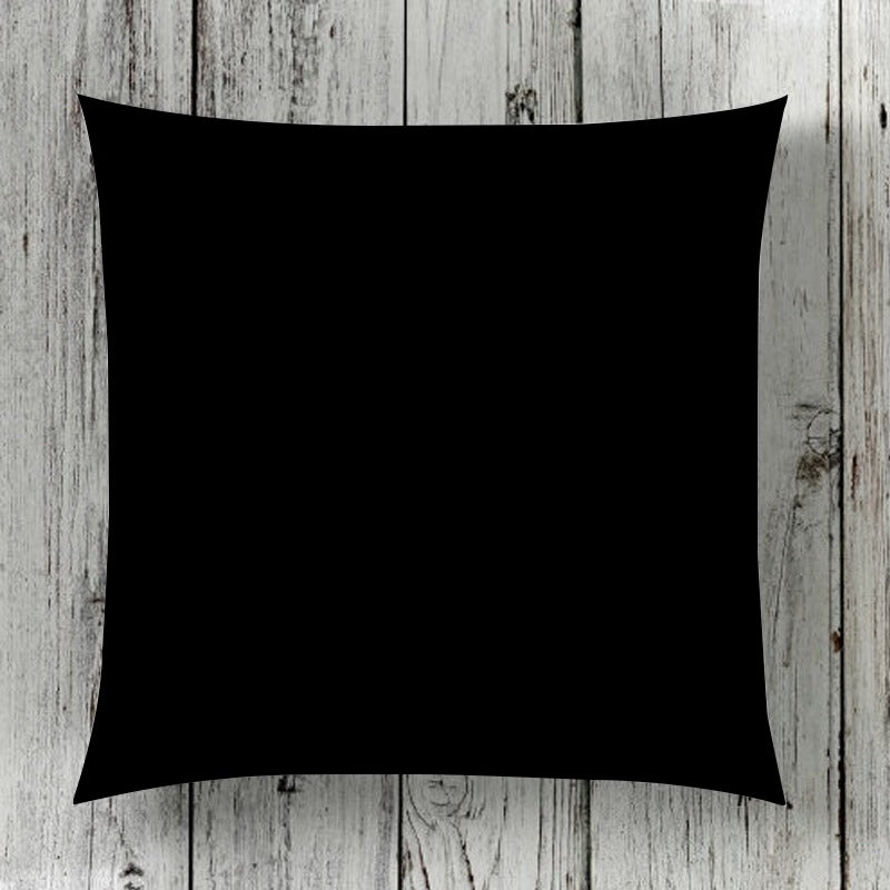 Plain black cushion cover displayed against wooden boards.