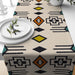Cream table runner with black geometric lines and coloured diamonds.