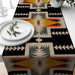 Black and beige geometric table runner with multicoloured diamond motifs.