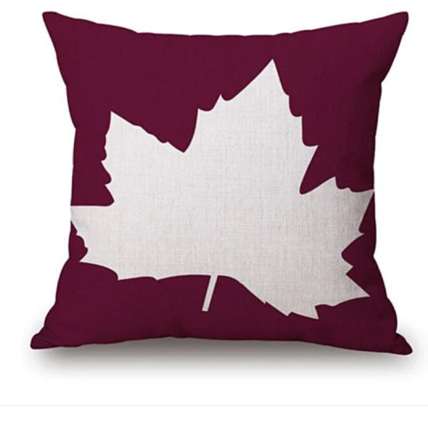 Burgundy cushion cover with a large white maple leaf.