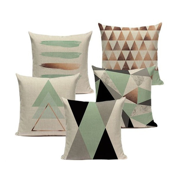 Five cream cushion covers with muted green, brown and black geometric designs.