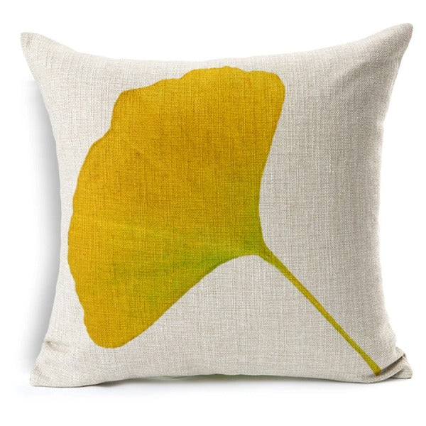 Cream cushion cover with a yellow and green fan-shaped leaf.