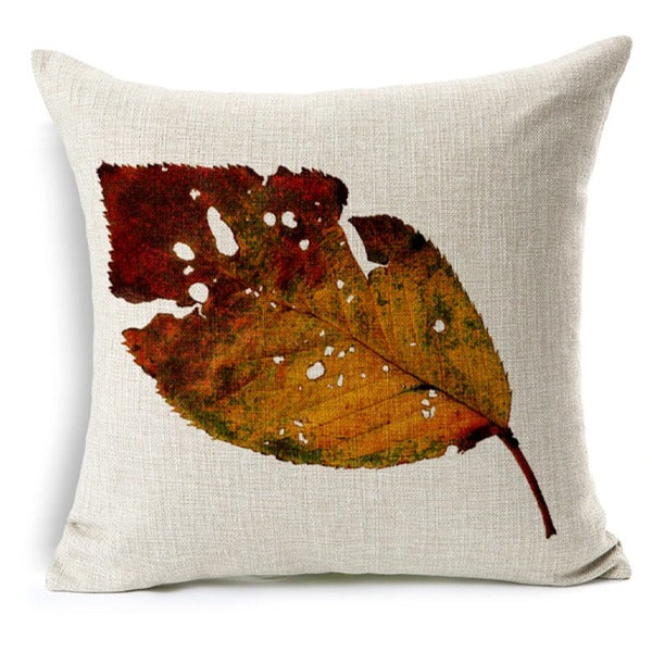 Cream cushion cover with a mottled brown and orange autumn leaf.