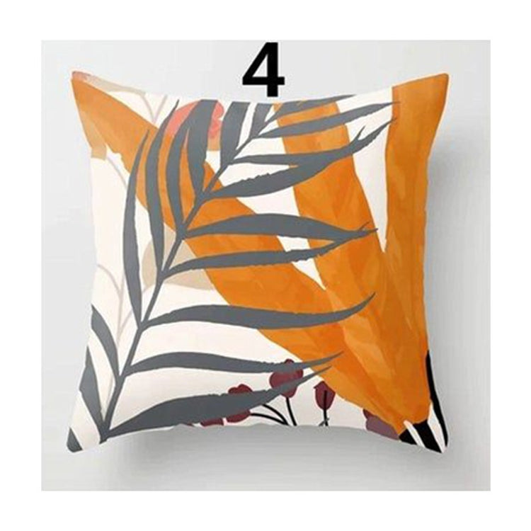 Cushion cover with grey leaves over orange and cream abstract shapes.