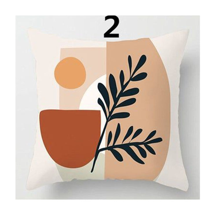 Peach cushion cover with a terracotta pot, an orange circle and a black leafy branch.