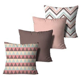 Four cushion covers in muted pink and brown with plain, triangle and chevron patterns.