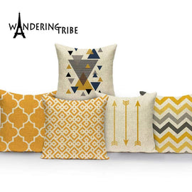 Five mustard, cream and black cushion covers with assorted geometric patterns.