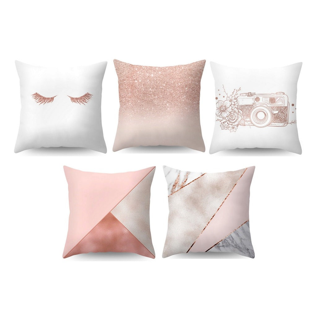 Five pale pink and cream cushion covers with geometric and illustrated designs.