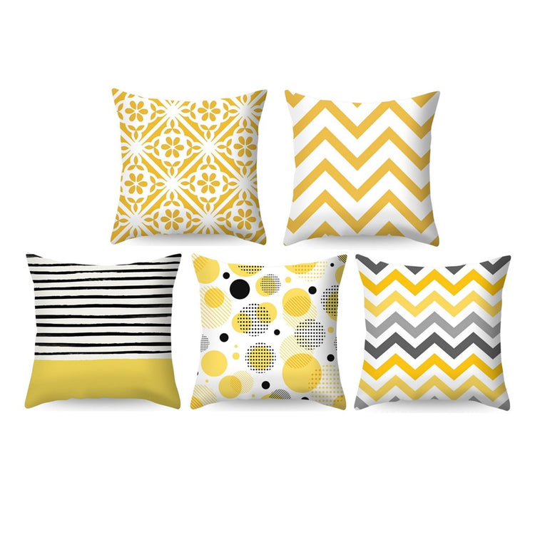 Five yellow, black and white cushion covers with floral, striped and geometric patterns.
