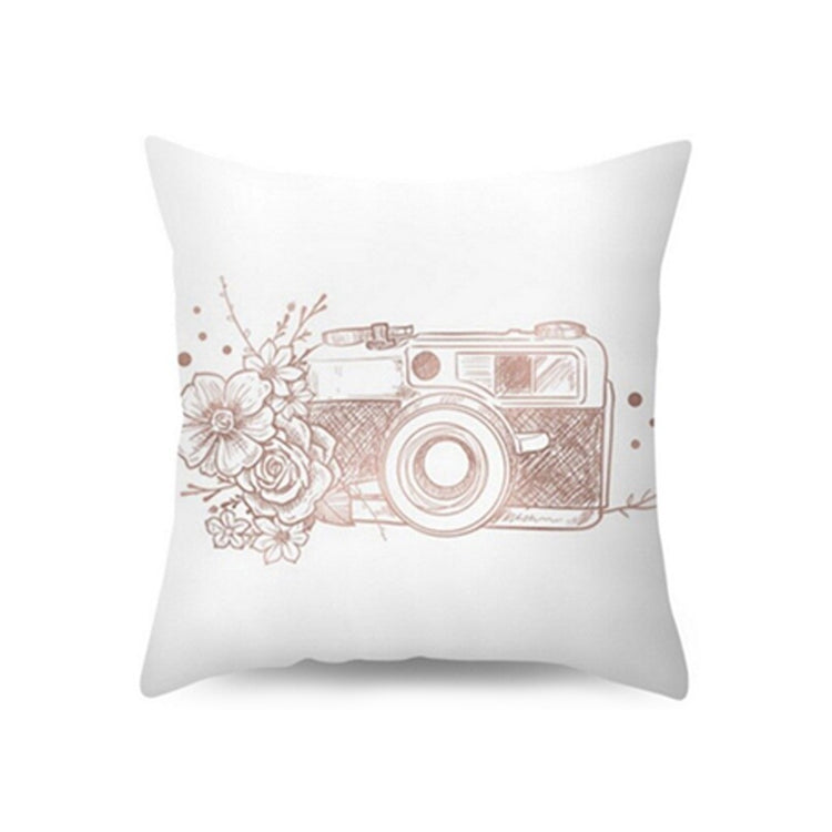 White cushion cover with a rose-toned camera and floral illustration.