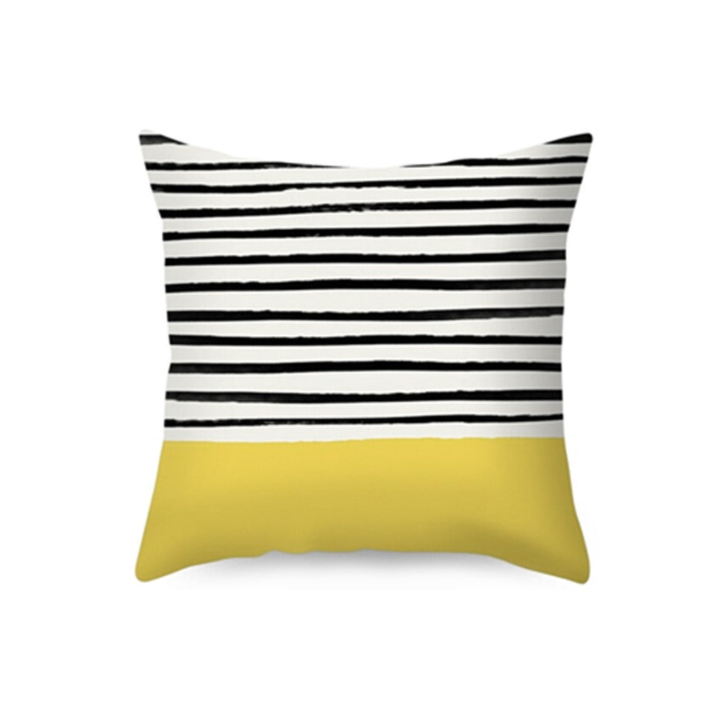 Cushion cover with black and white stripes above a mustard yellow panel.