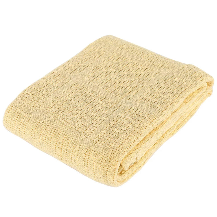 Folded pale yellow textured blanket on a white background.