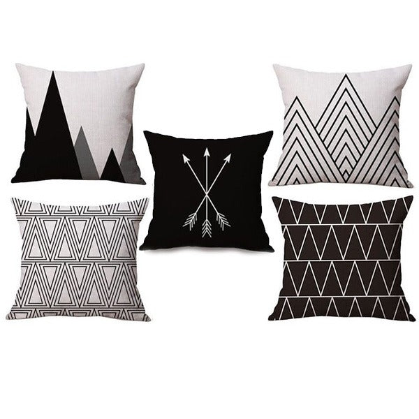 Five black and white cushion covers with assorted triangular geometric patterns.
