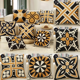 Black, cream and gold geometric cushion covers arranged together.