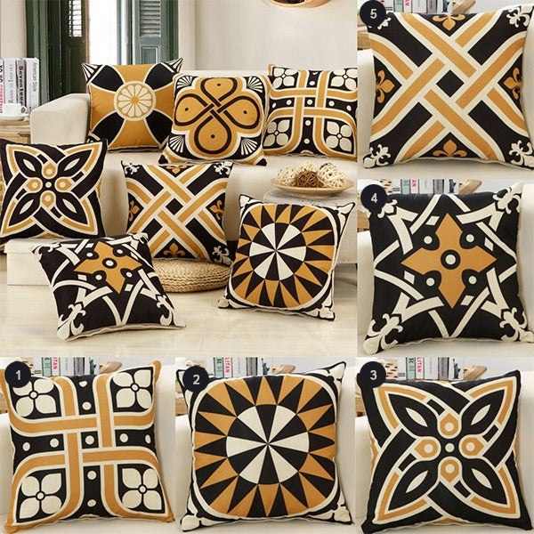 Black, cream and gold geometric cushion covers arranged together.