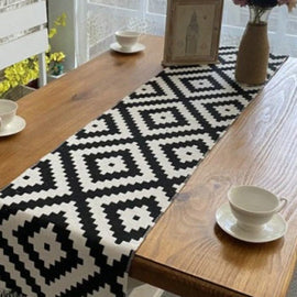 Black and white diamond-pattern table runner on a wooden table.