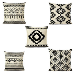 Five cream and black cushion covers with geometric striped and diamond patterns.