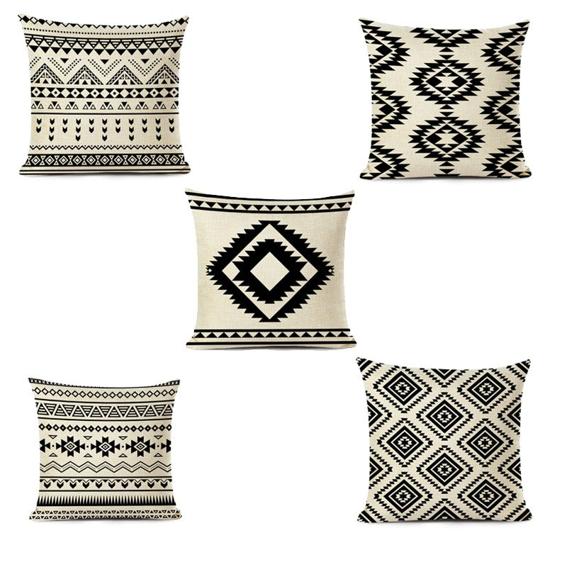 Five cream and black cushion covers with geometric striped and diamond patterns.