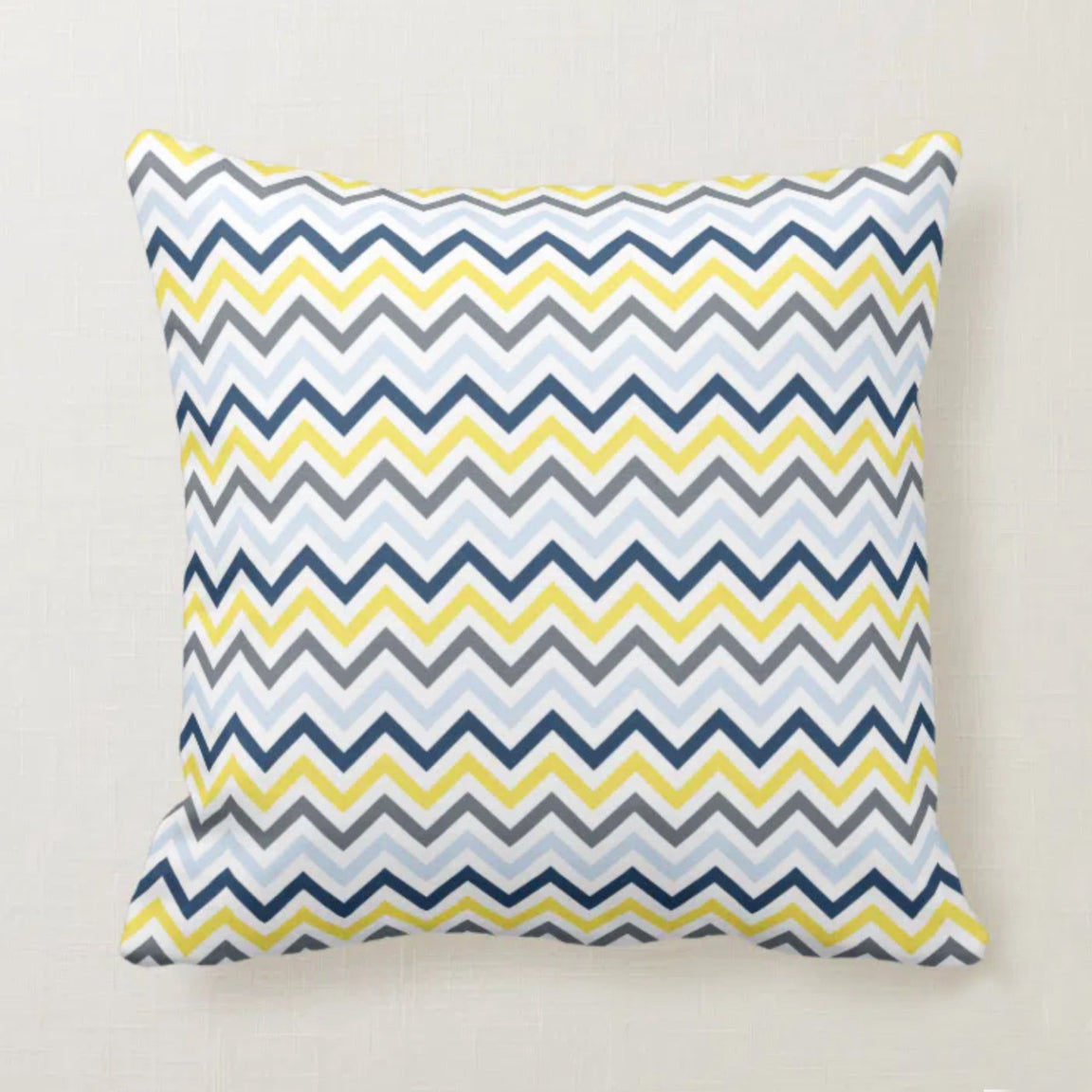 Cushion cover with fine navy, yellow, grey and white zigzag stripes.