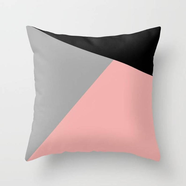 Cushion cover with blush pink, grey and black geometric panels.