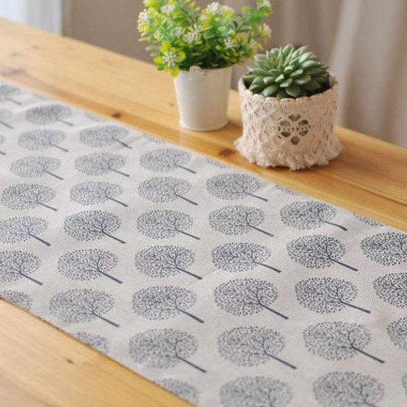 Light beige tree-pattern table runner displayed along a dining table.