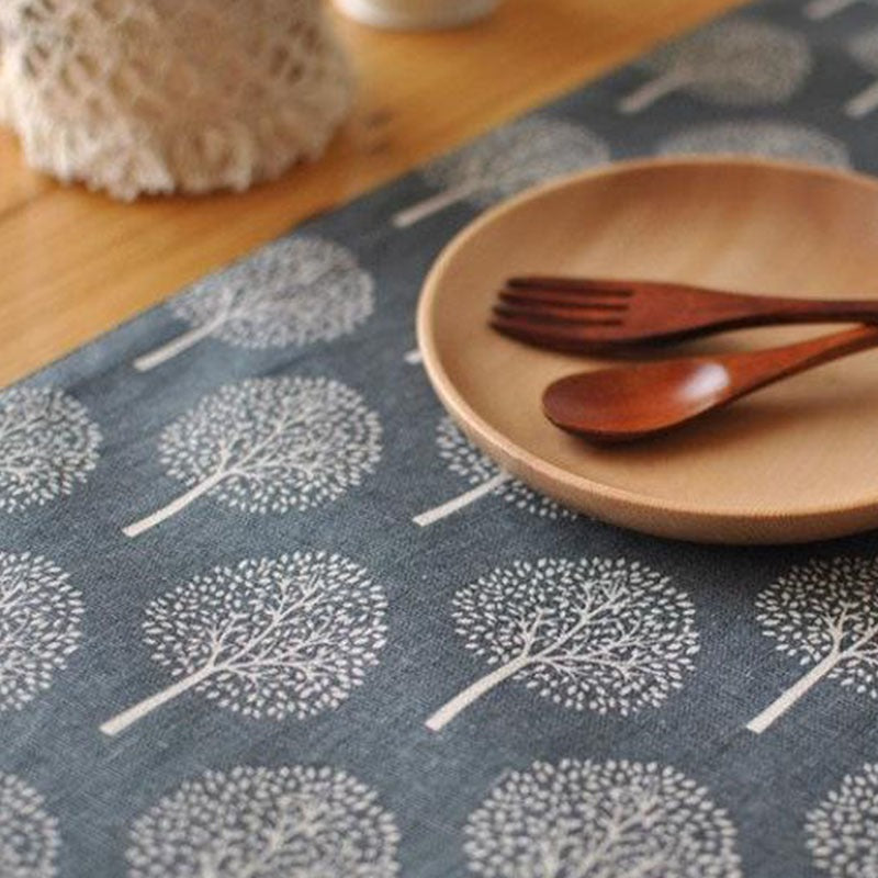 Grey tree-pattern table runner shown beneath a plate and cutlery.