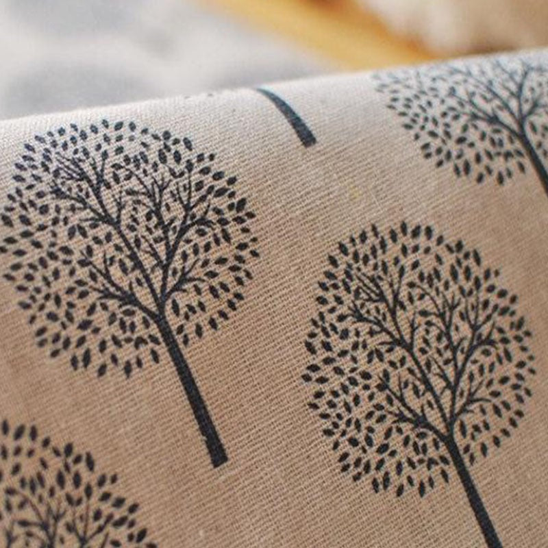 Close-up of tree motifs on light beige table-runner fabric.