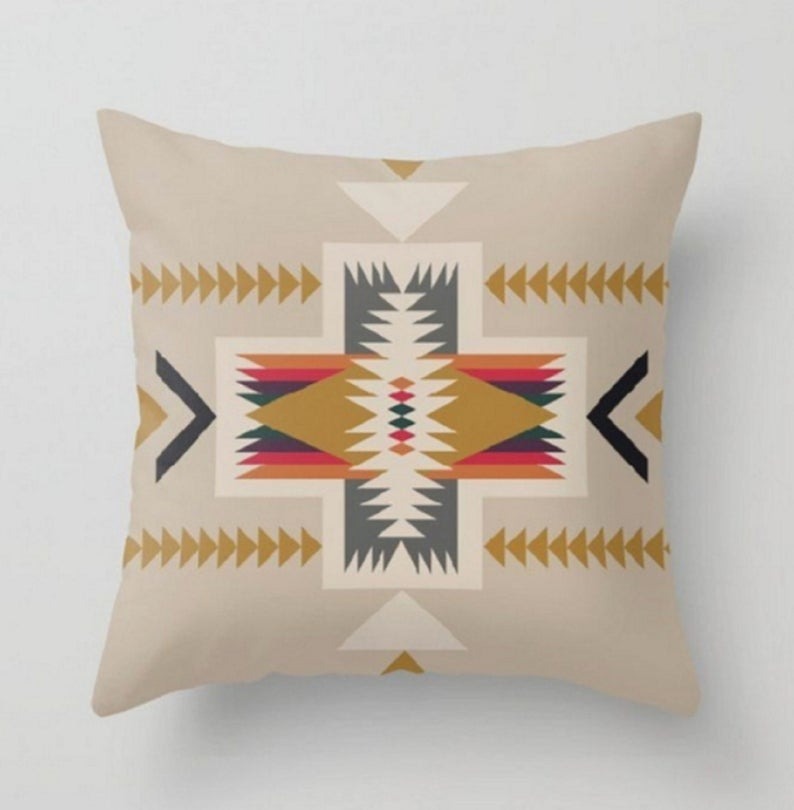 Beige cushion cover with a large multicoloured geometric star motif.