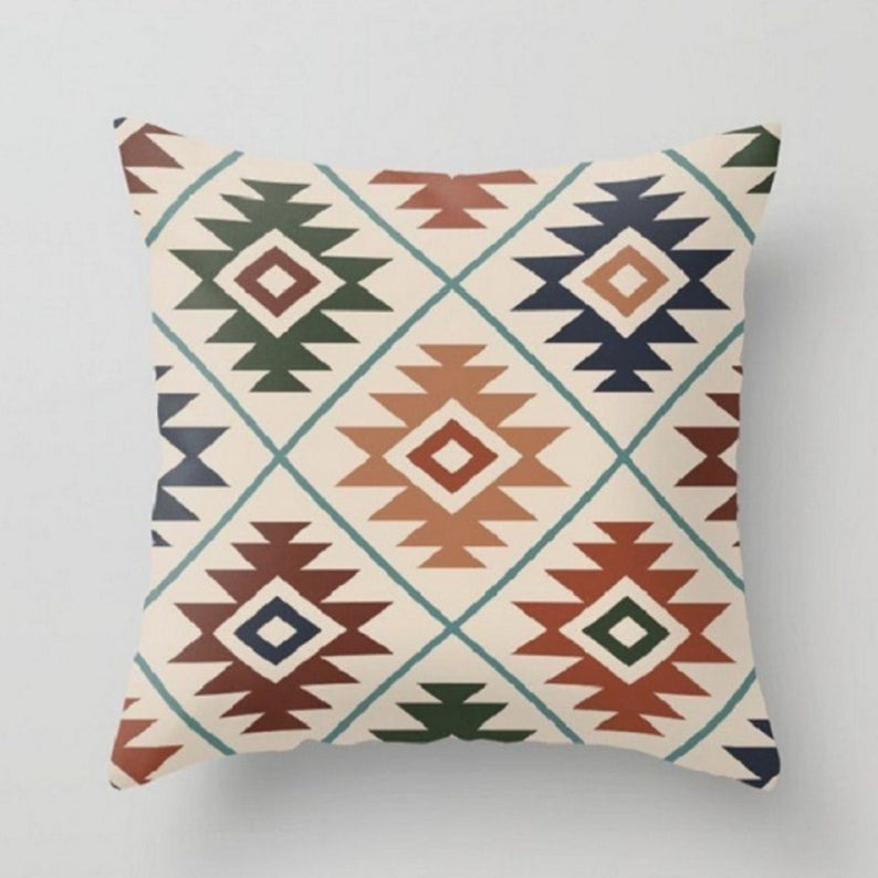 Cream cushion cover with multicoloured stepped diamond motifs.