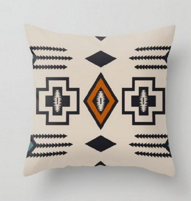 Cream cushion cover with black geometric outlines and an orange central diamond.