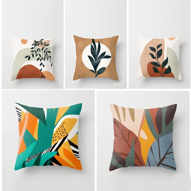 Five cushion covers with abstract botanical designs in warm and green tones.