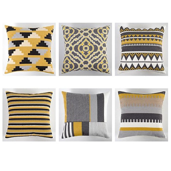 Six cushion covers with yellow, grey and black geometric patterns.