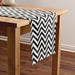 Black and white chevron table runner on a wooden table.