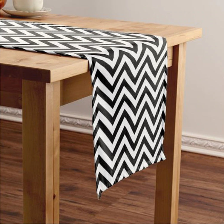 Black and white zigzag table runner on a wooden table.