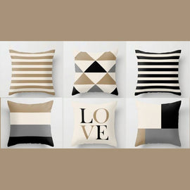 Six beige, white and black cushion covers with stripes, triangles, colour blocks and LOVE lettering.