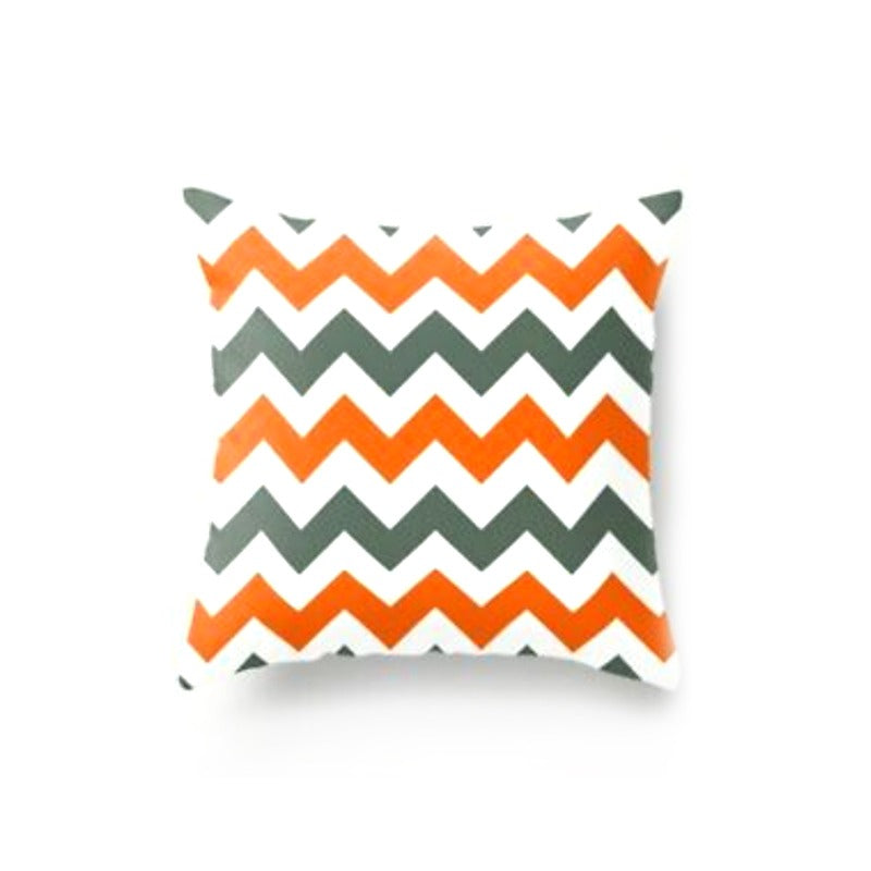 Cushion cover with orange, grey and white zigzag stripes.