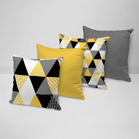 Four cushion covers in yellow, grey and black with plain and triangle patterns.