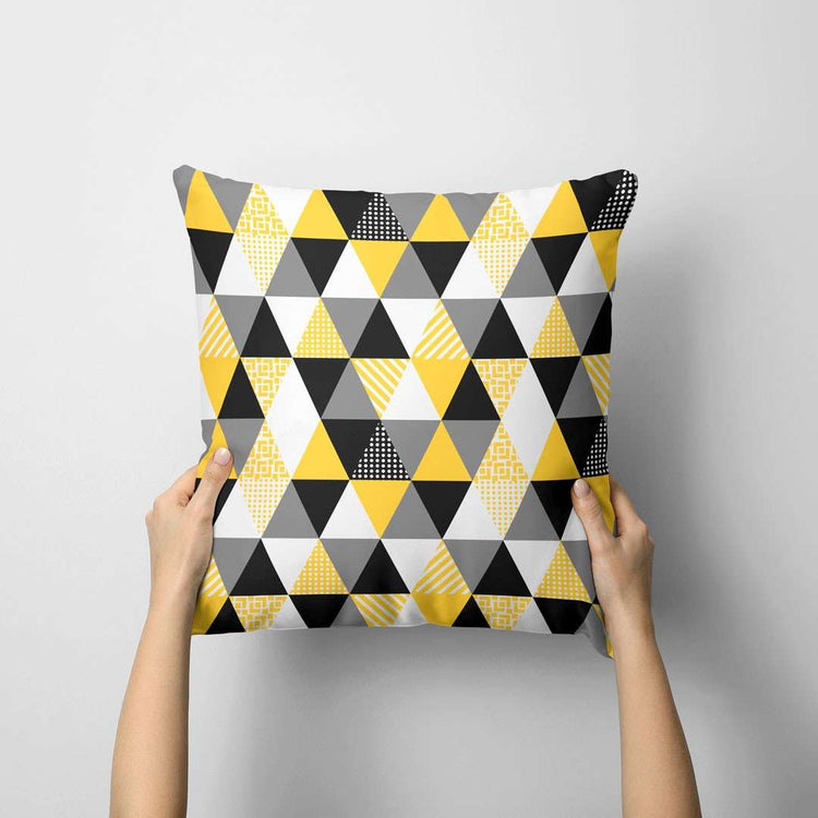 Cushion cover with small yellow, grey, black and white triangles.