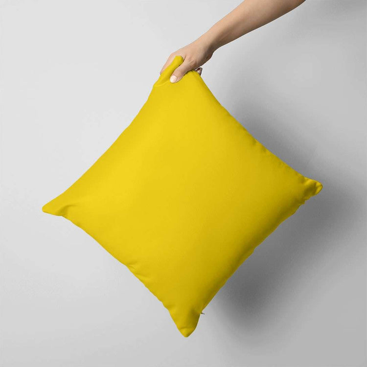 Plain bright yellow cushion cover held against a grey background.