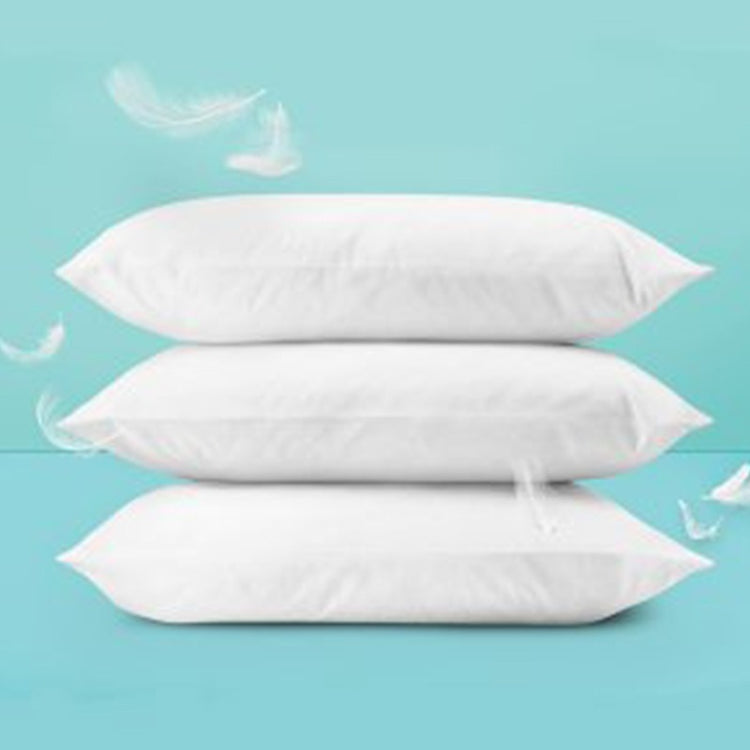 Three white fibre-filled pillows stacked against a turquoise background.