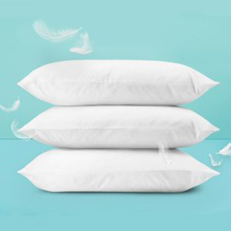 Three white fibre-filled pillows stacked against a turquoise background.