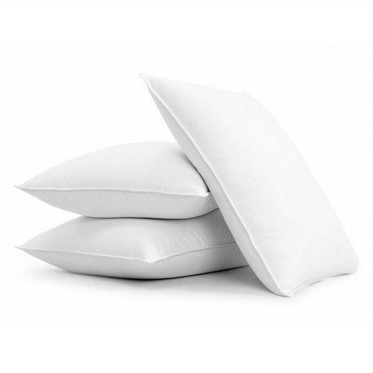 White fibre-filled pillows stacked against a white background.