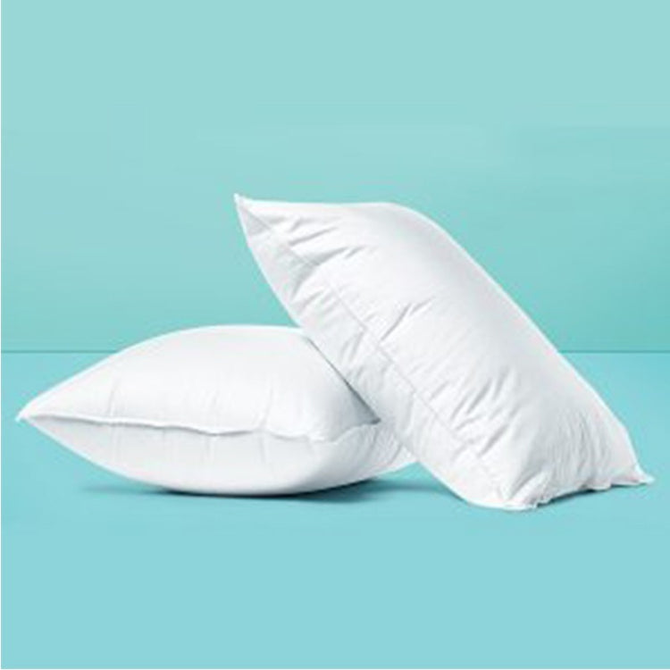Two white fibre-filled pillows against a turquoise background.