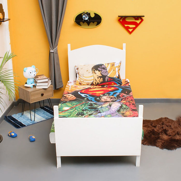 Colourful superhero-print children's bedsheet and matching pillowcase on a single bed.