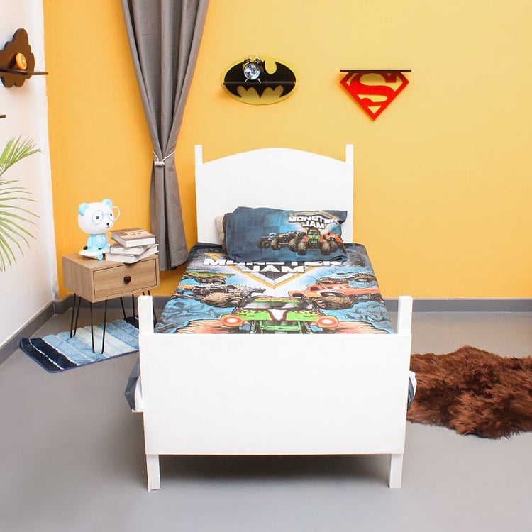 Front view of a single bed dressed in a monster truck-print bedsheet.