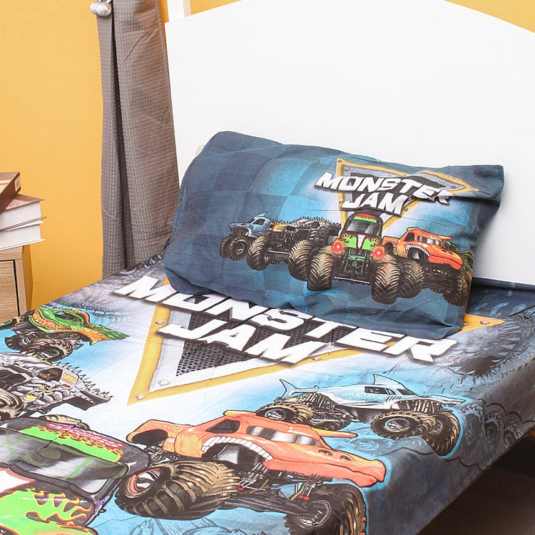 Close view of the monster truck design on a children's bedsheet and pillowcase.