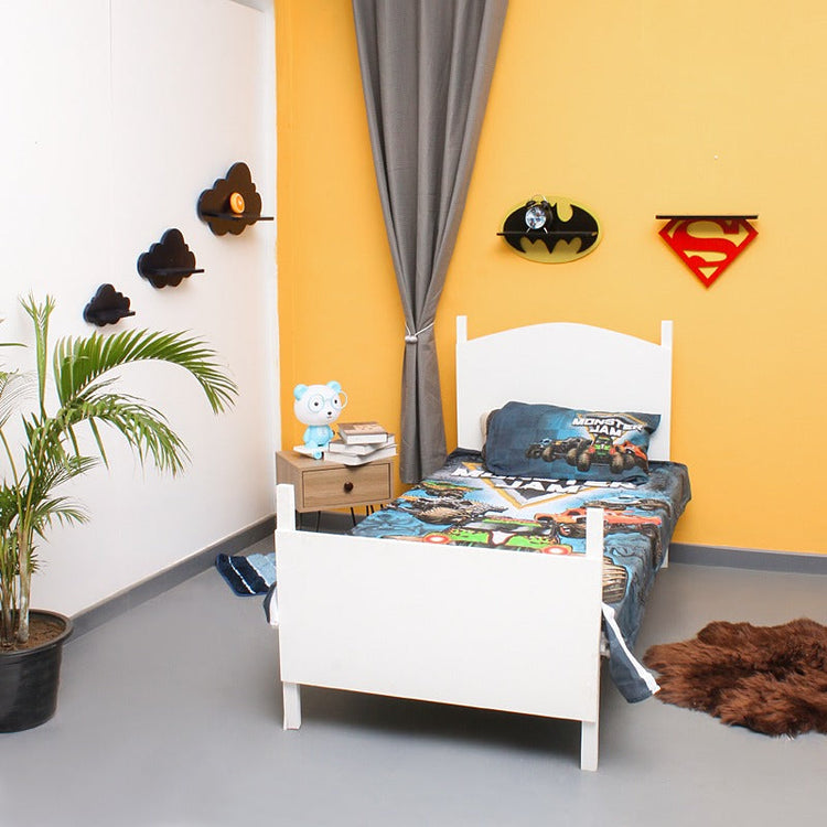 Angled room view of a monster truck-print children's bedsheet on a single bed.